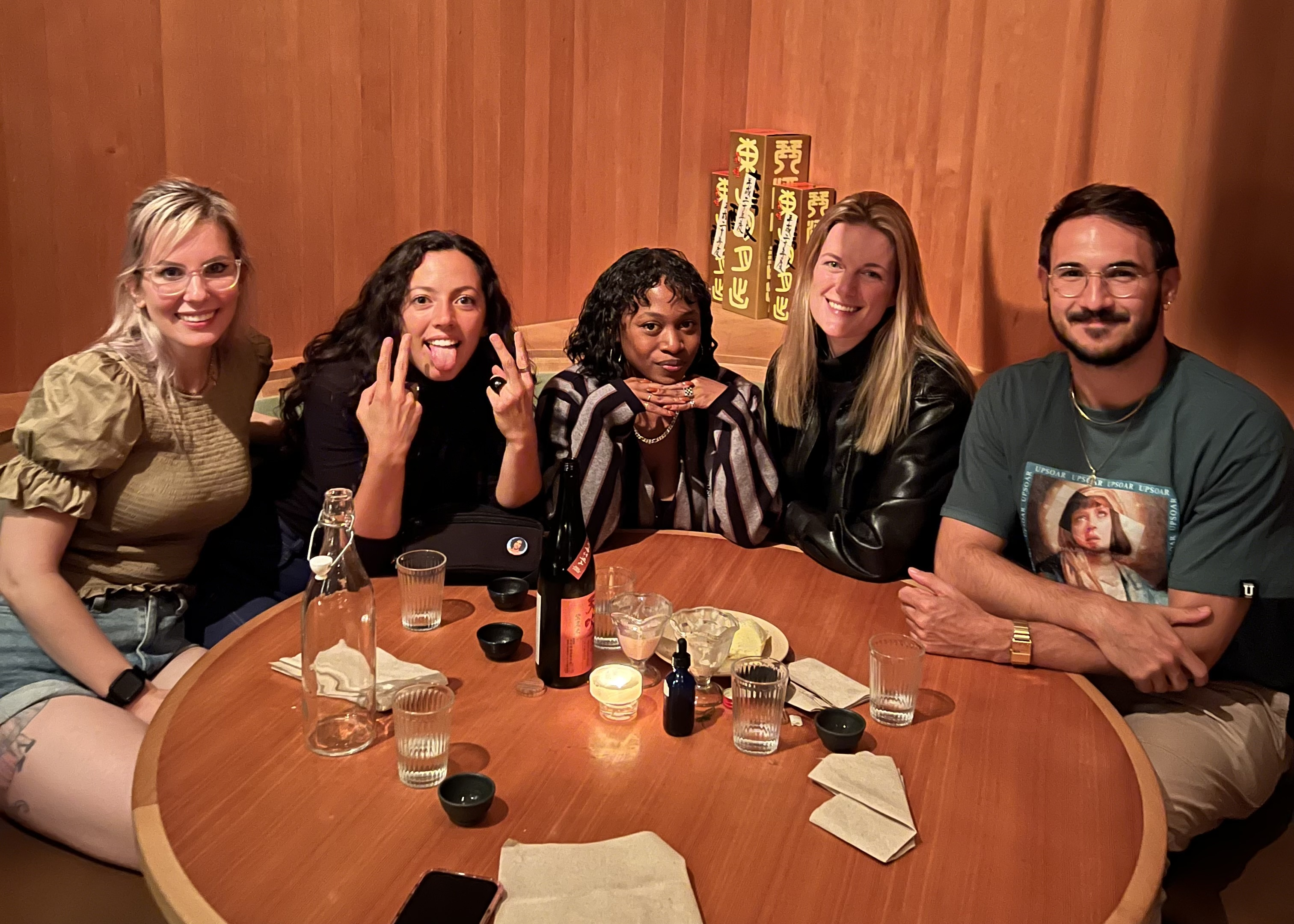 Group photo of five members at dinner